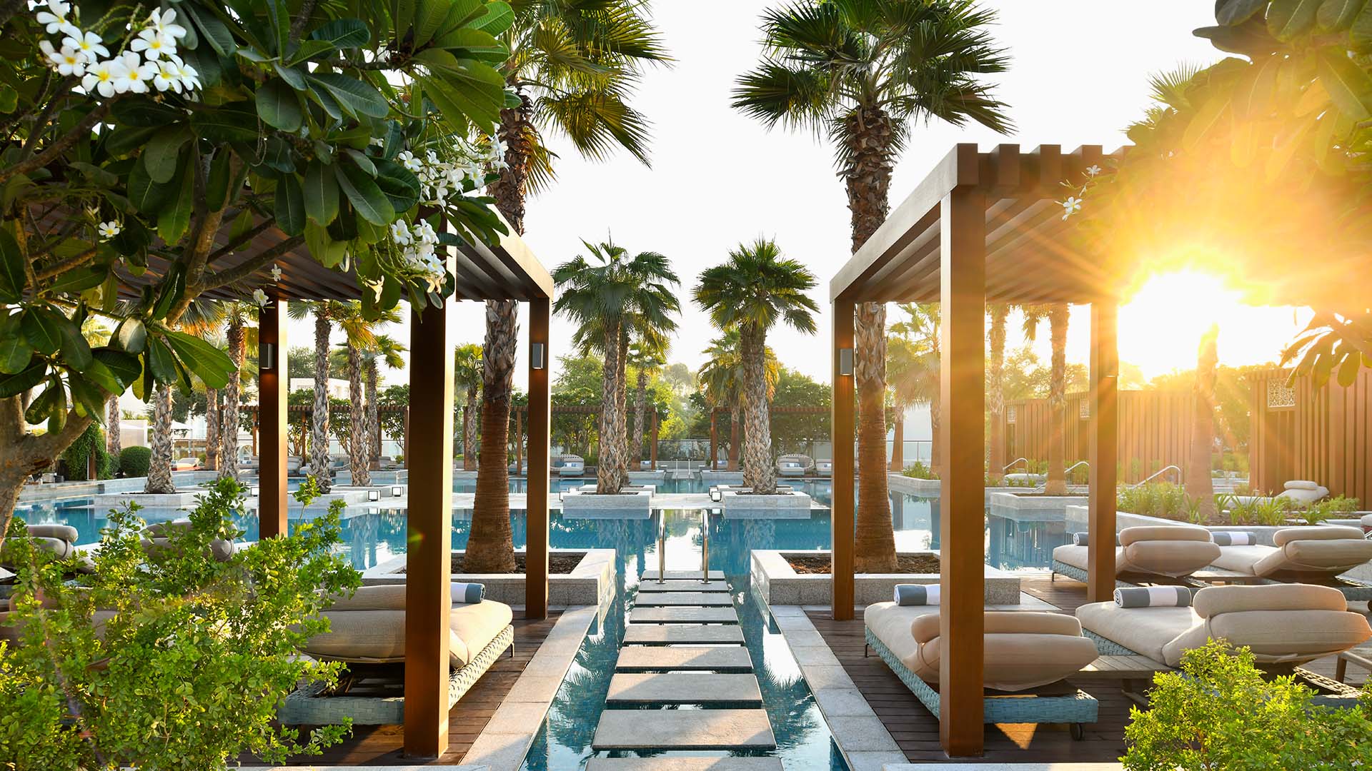 Palm trees and cabanas at the pool at Al Messila, a Luxury Collection Resort & Spa in Doha