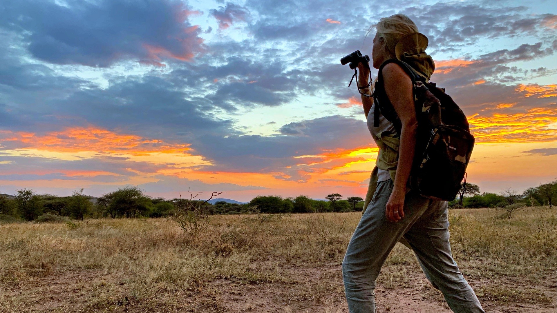 woman with binoculars on an African walking safari in Zambia