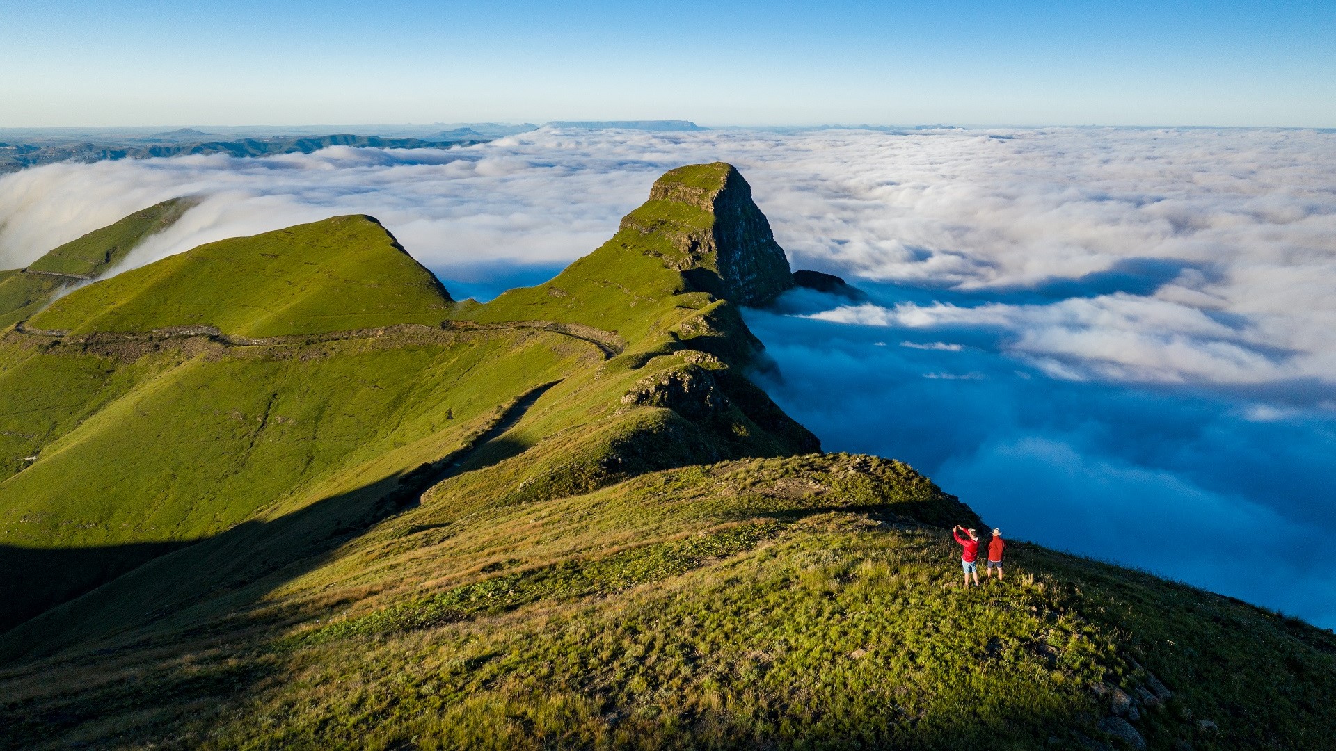 two hikers atop a Drakensburg mountain above the clouds in South Africa