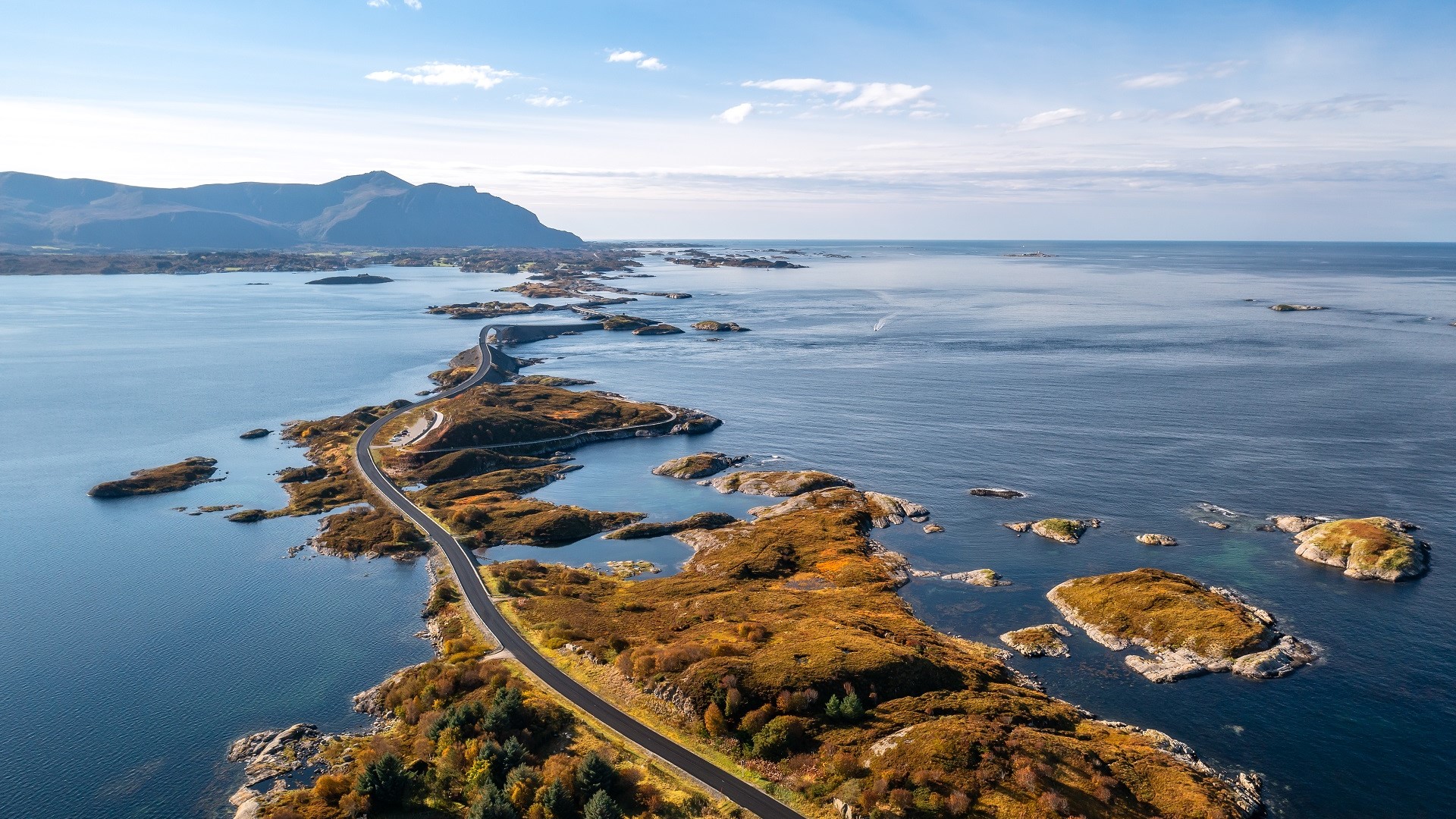 Nordic road going through water to island of mountains