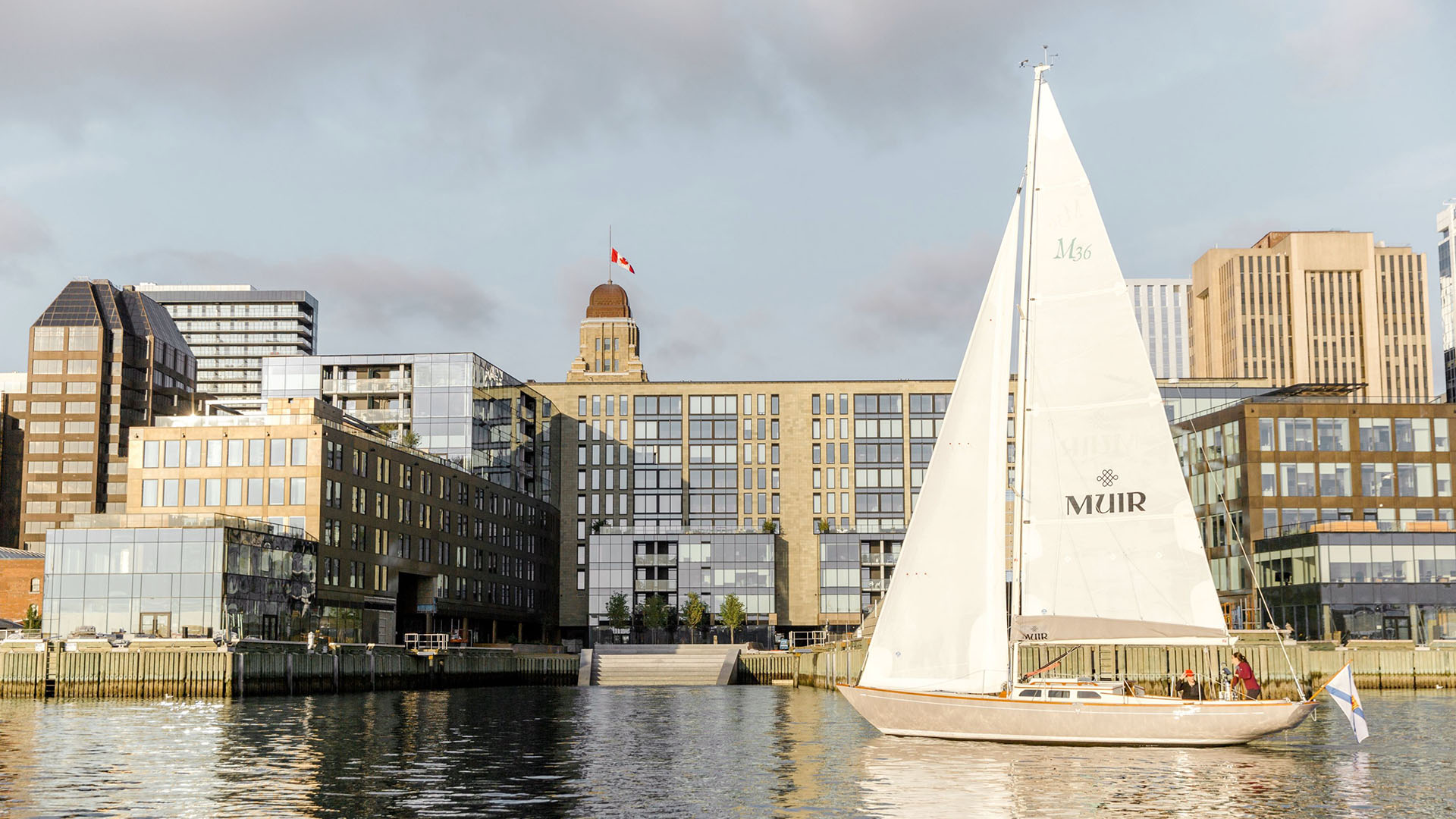 Muir, Autograph Collection hotel and a sailboat on the Halifax waterfront
