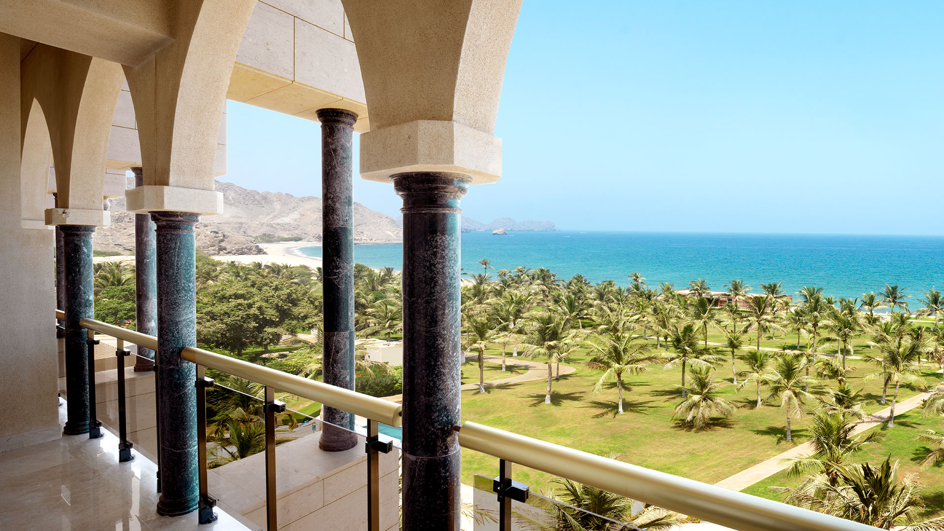marble patio and view of palm trees and the Sea of Oman at Al Bustan Palace, a Ritz-Carlton Hotel