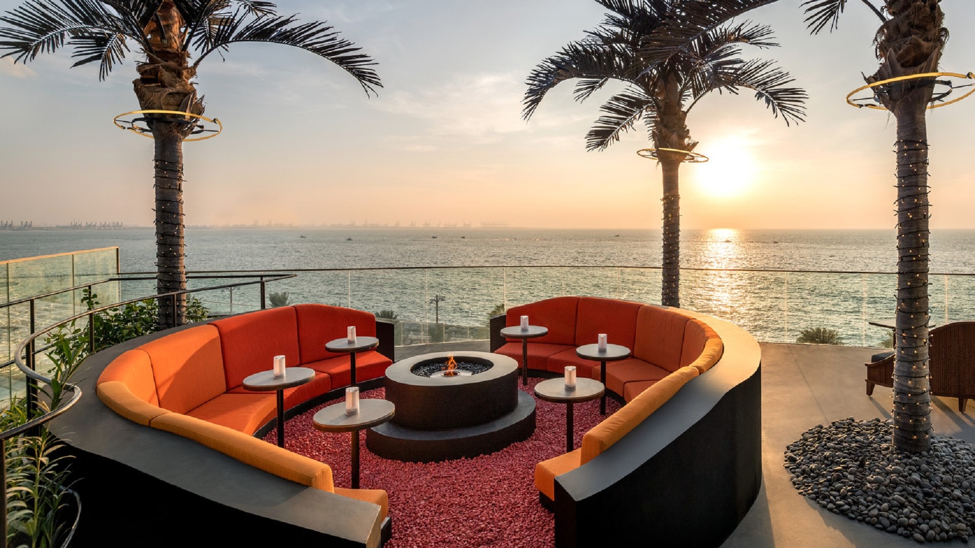 outdoor seating and palm trees overlooking water on Palm Jumiera Island; SoBe Dubai bar
