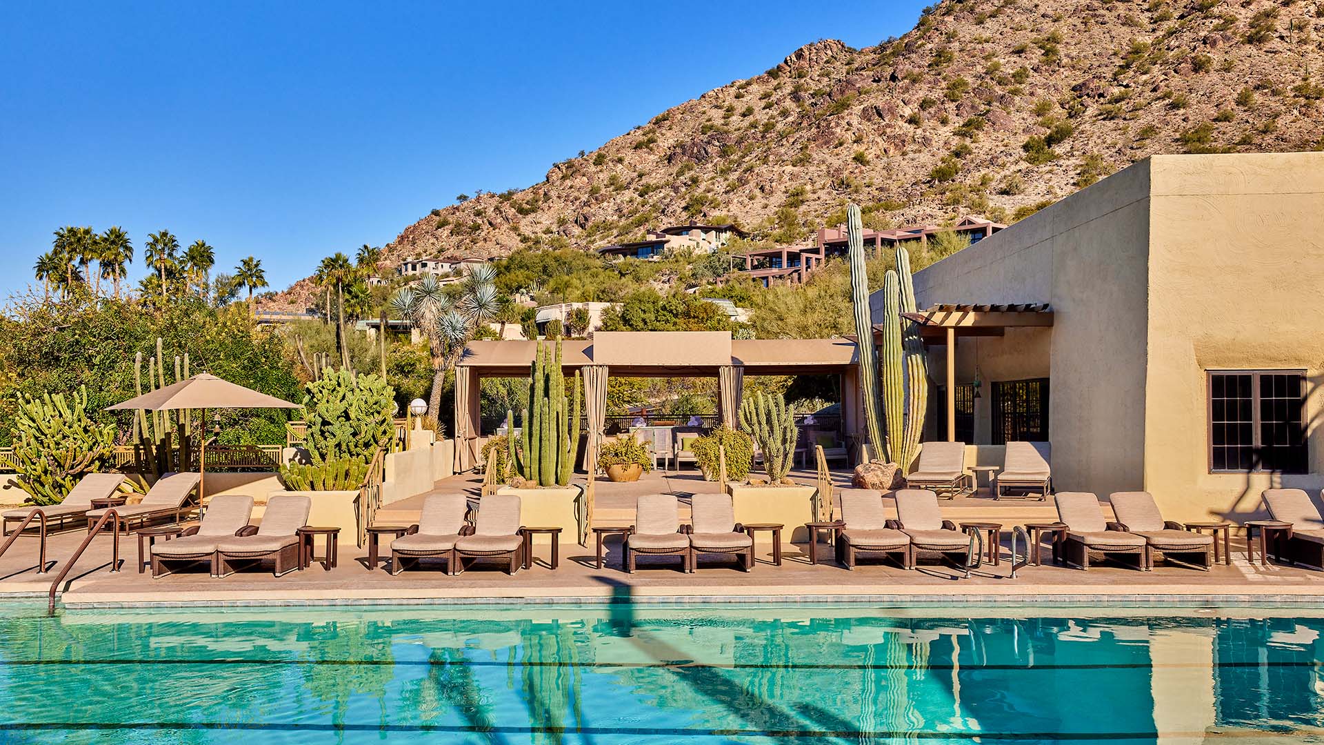 spa pool and cabanas in desert mountains with palm trees and cacti at the JW Marriot Scottsdale Camelback Inn Resort & Spa