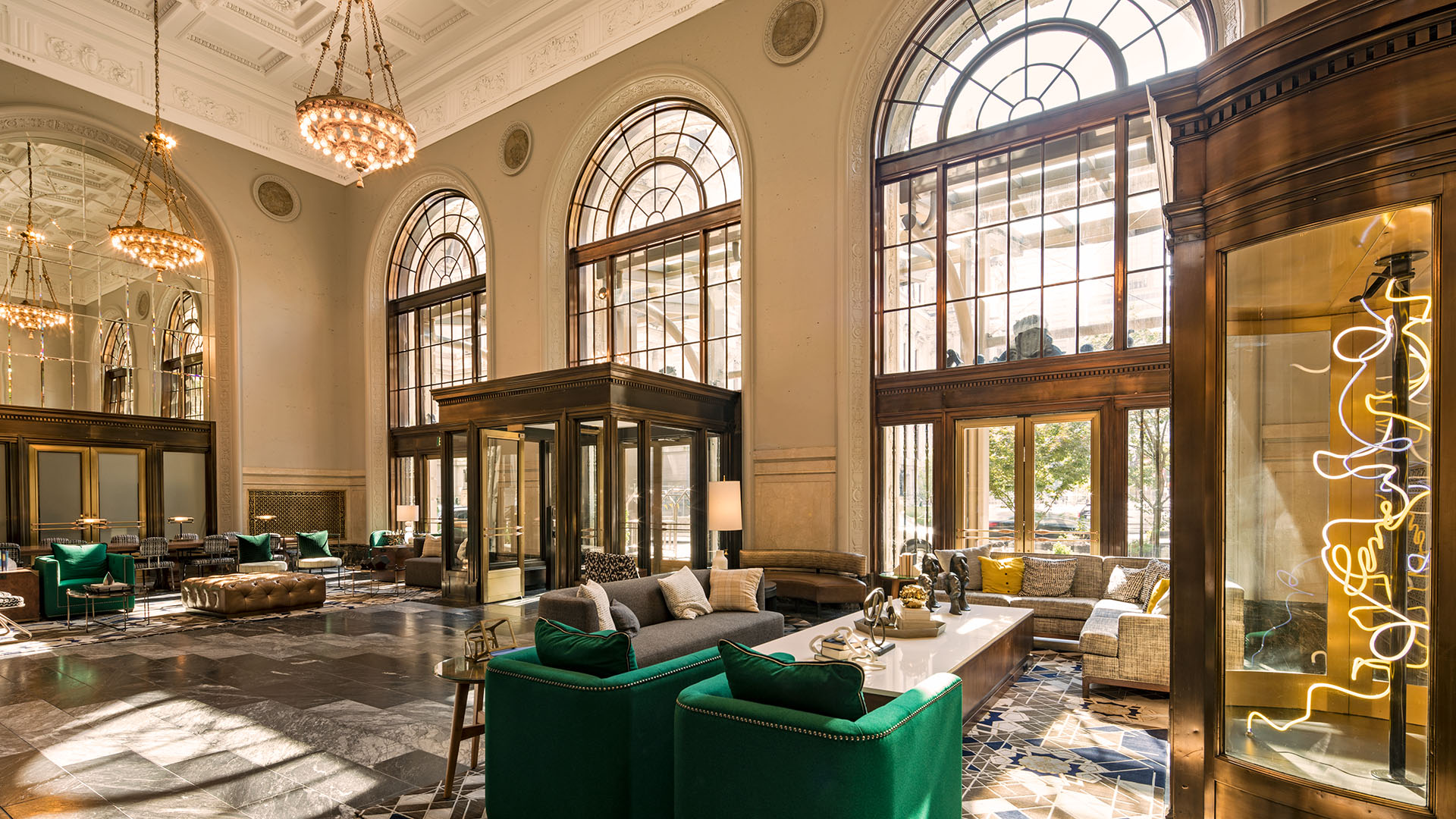 historic palatial hotel lobby with chandeliers and arched windows at The Notary Hotel, Autograph Collection in Philadelphia