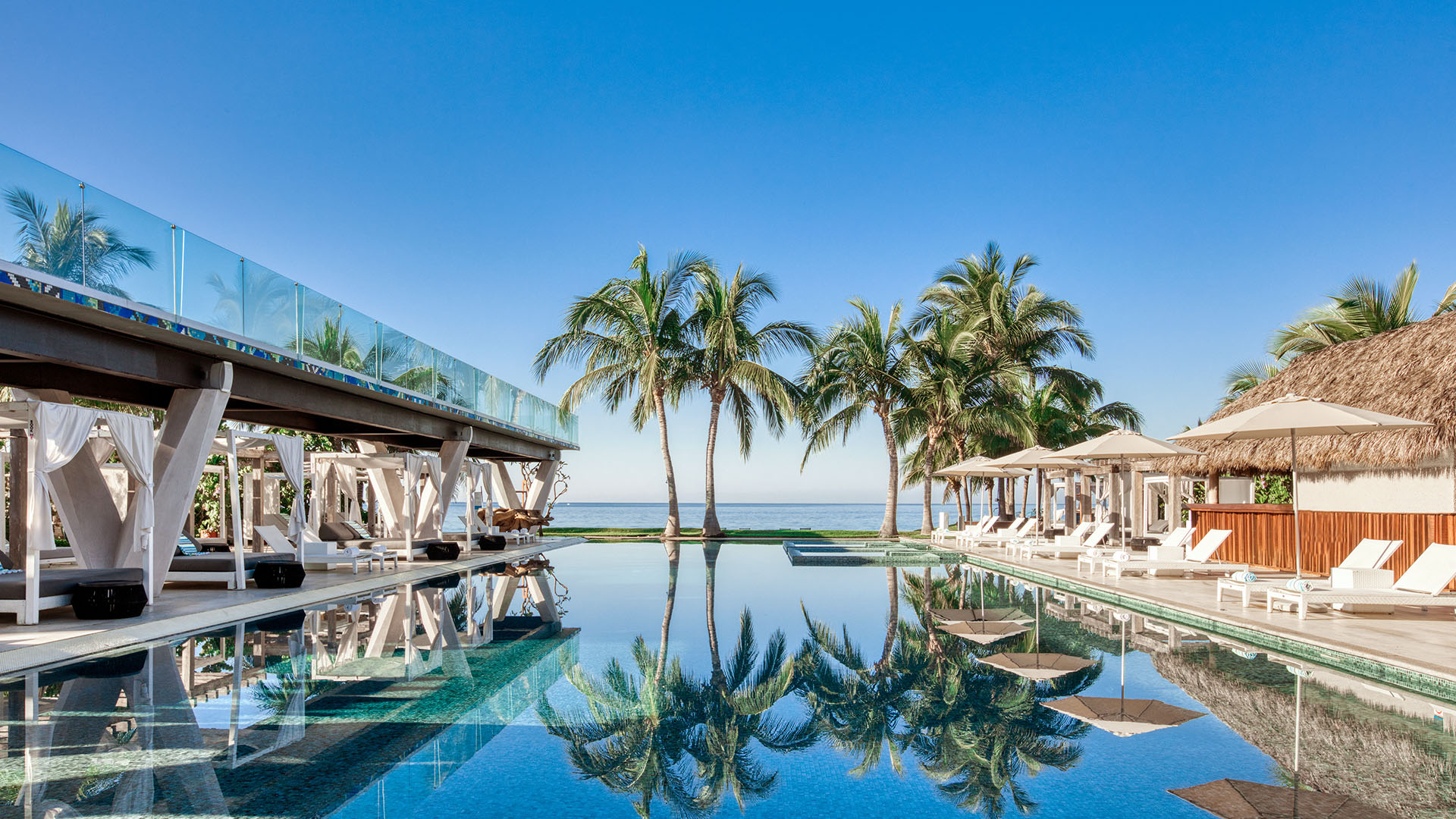 Pool cabanas and palm trees at W Punta Mita in Costa Rica