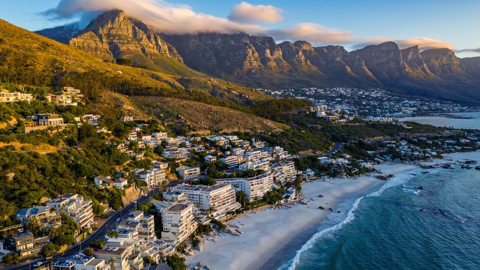 mountains above white sand beaches and Cape Town at Clifton Fourth South African beach