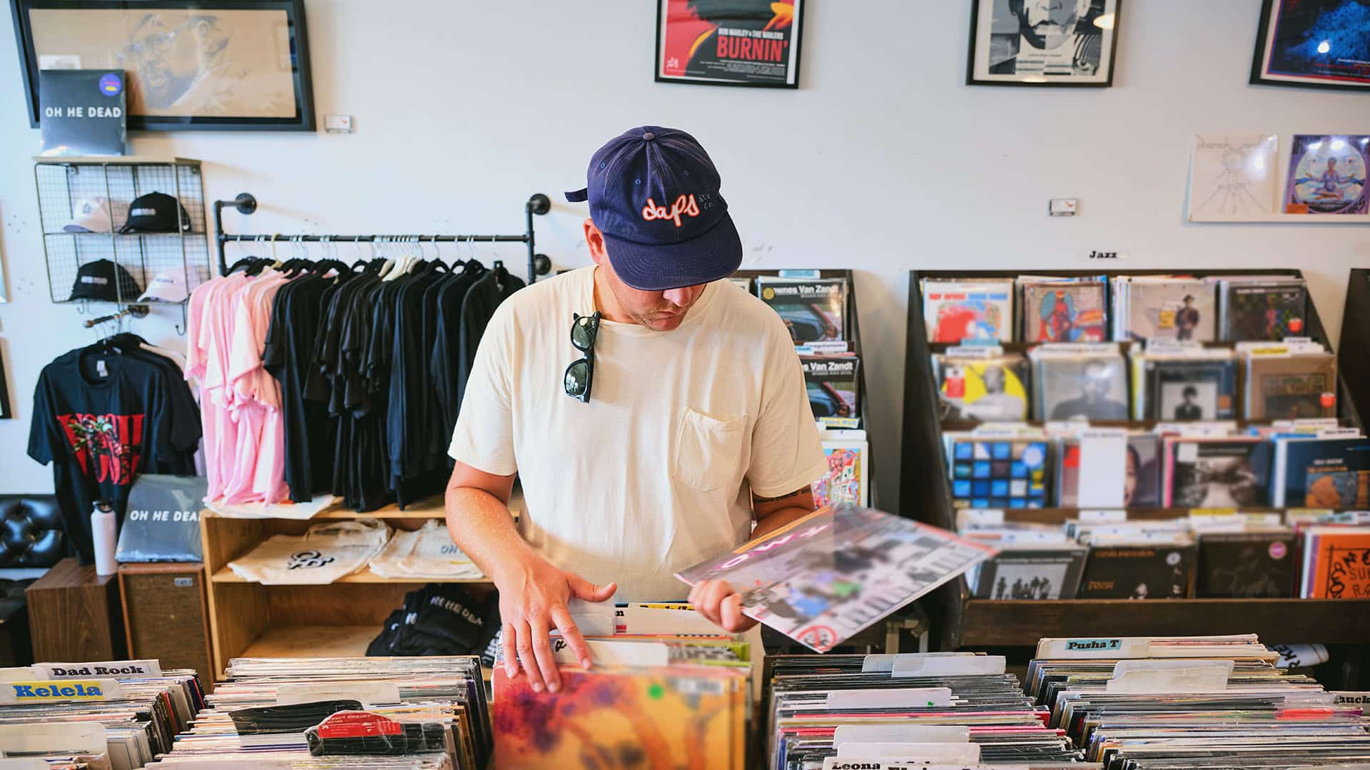 person picking up vinyl record while shopping at Byrdland Records