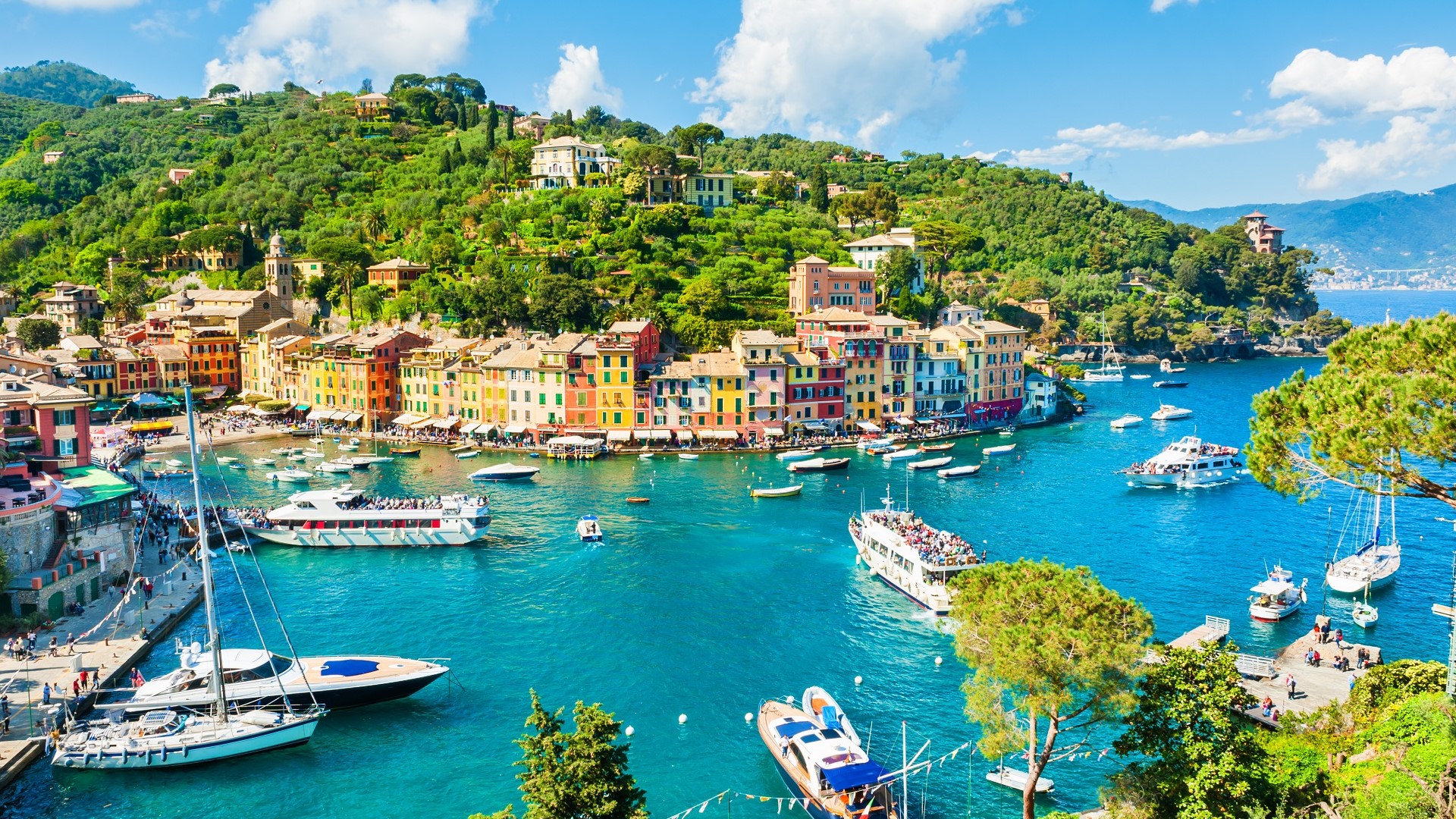 aerial view of boats and waterfront buildings around a harbor in Portofino, Italy