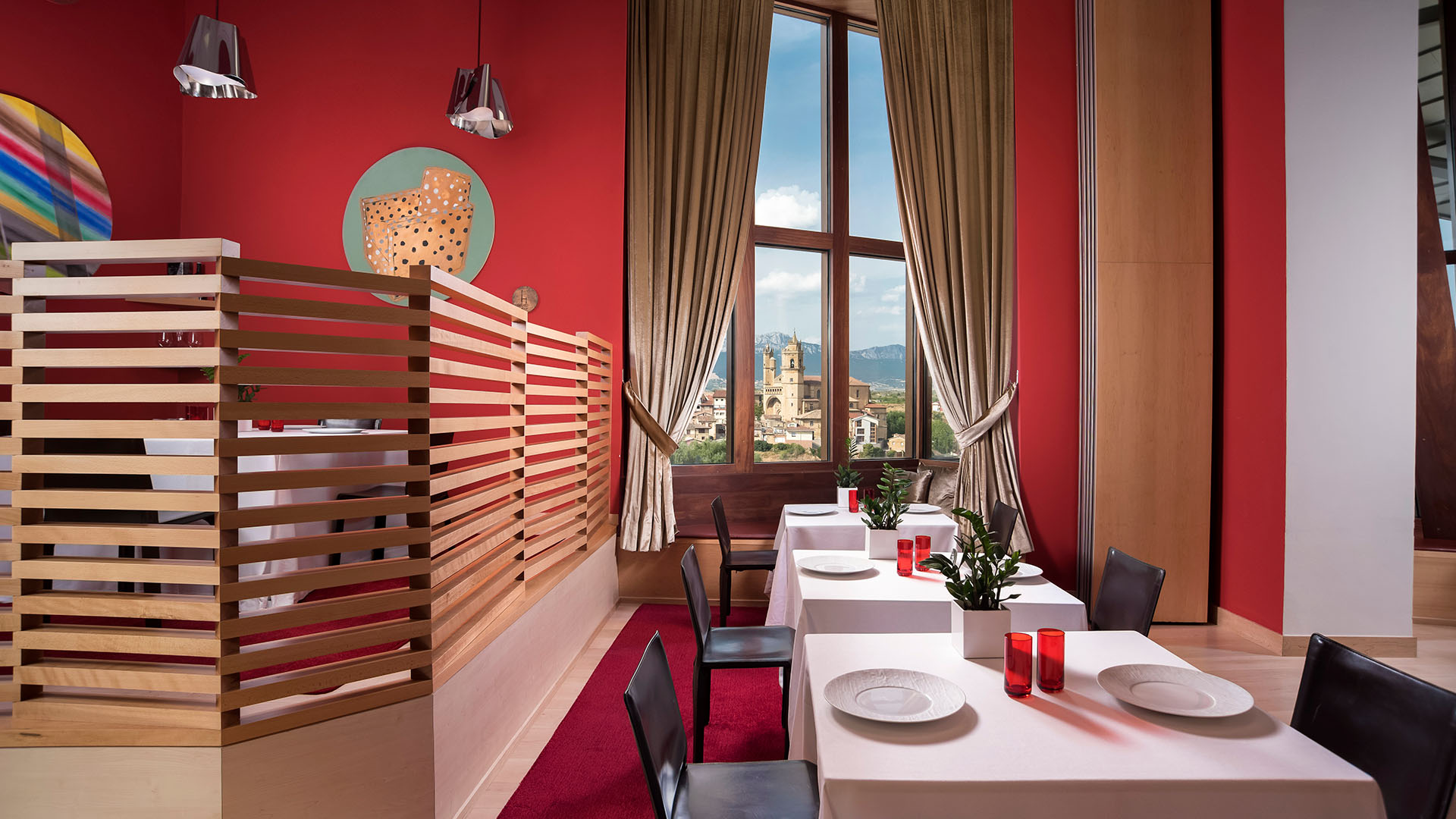 red walled interior with view of old town at marques de riscal restaurant