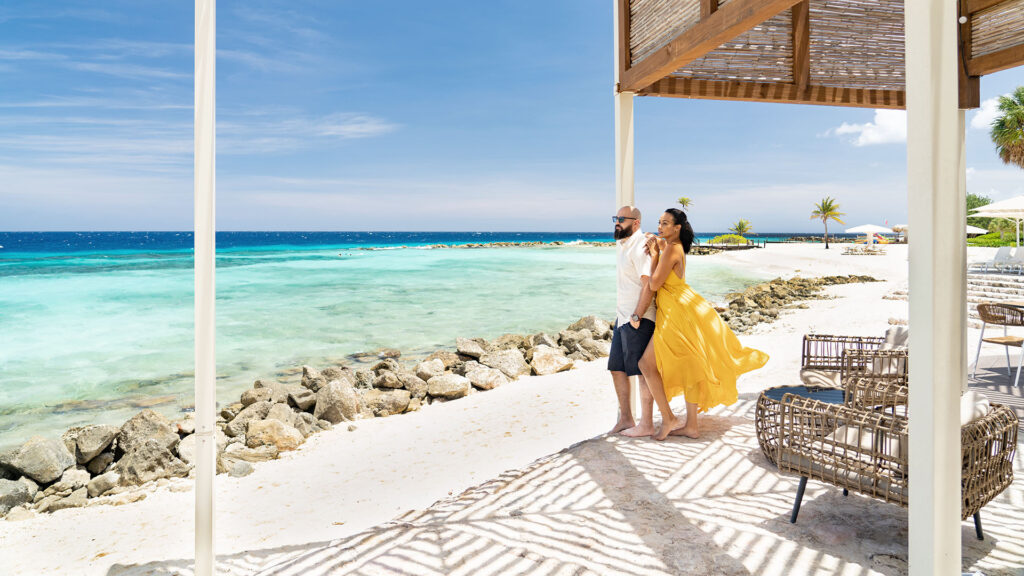 a couple embrace on a private beach at Curacao Marriott Beach Resort