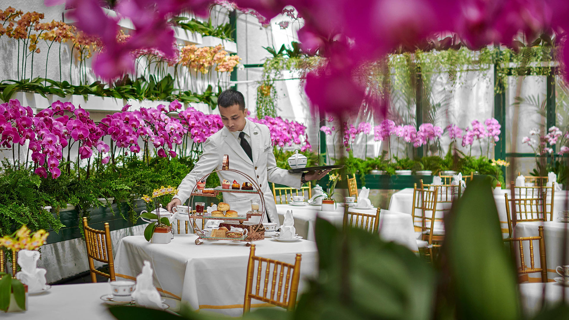a waiter sets a table for afternoon tea at The Majestic Hotel Kuala Lumpur, Autograph Collection