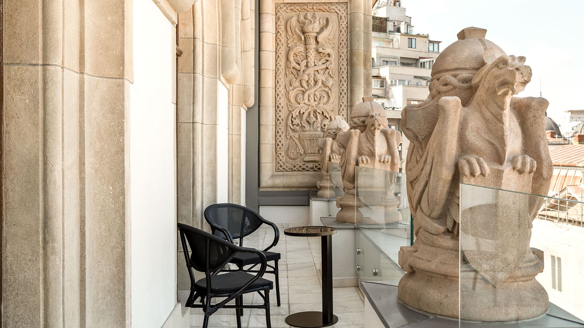 balcony with ornate stonework and a small table and chairs at The Marmorosch Bucharest, Autograph Collection