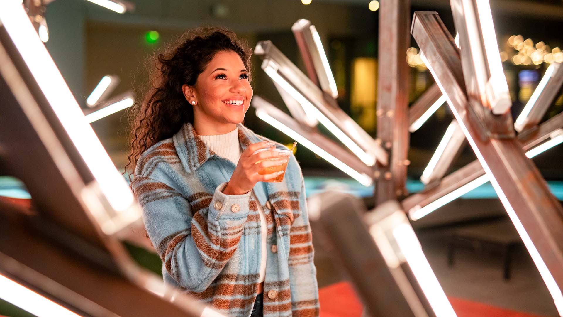 a woman smiles and holds a drink at the Marriott Marquis Houston