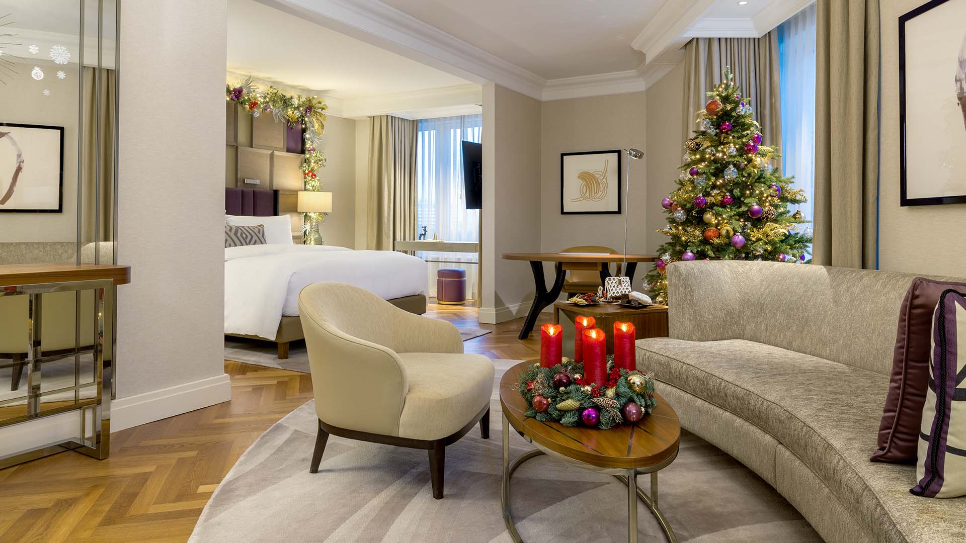 a guest room at The Ritz-Carlton, Berlin with a lit Christmas tree and other seasonal decor