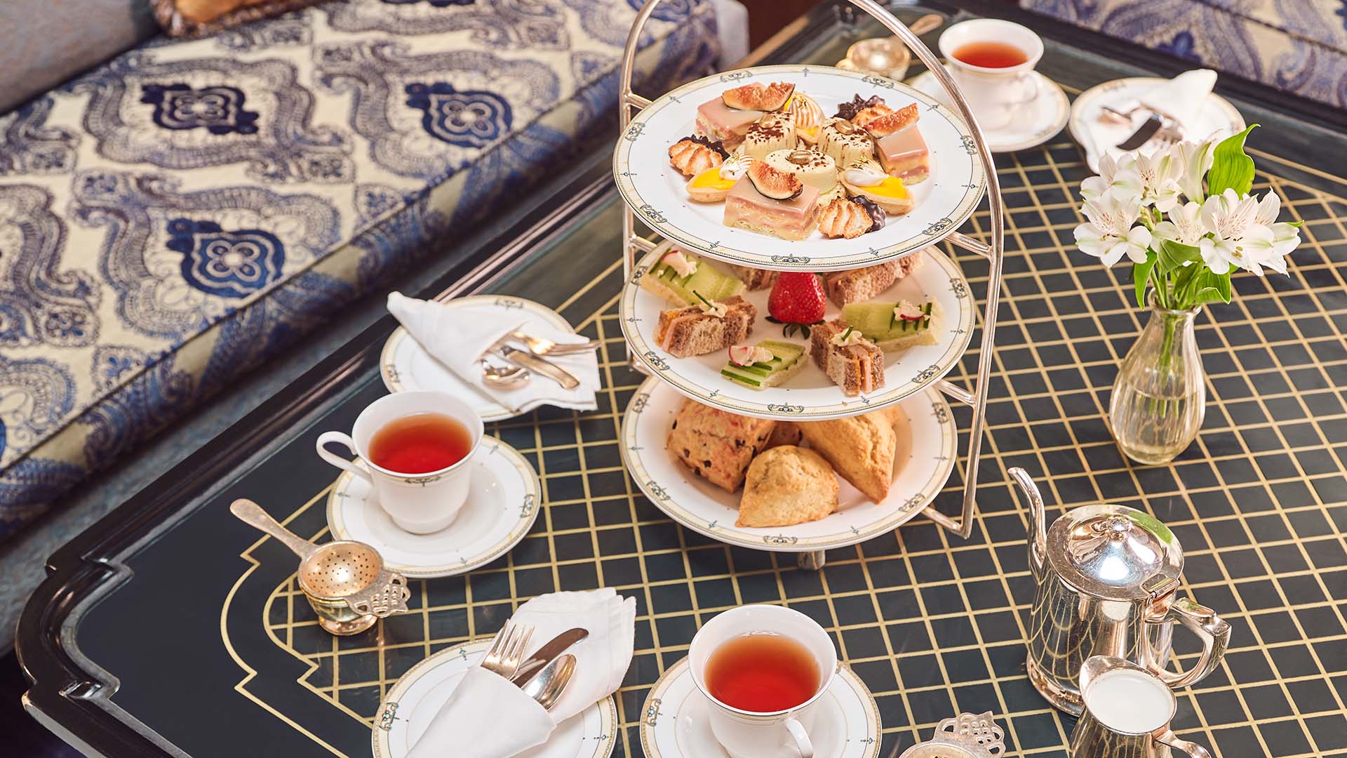 Afternoon Tea food and drink arranged on a low table at The Brown Palace Hotel and Spa, Autograph Collection