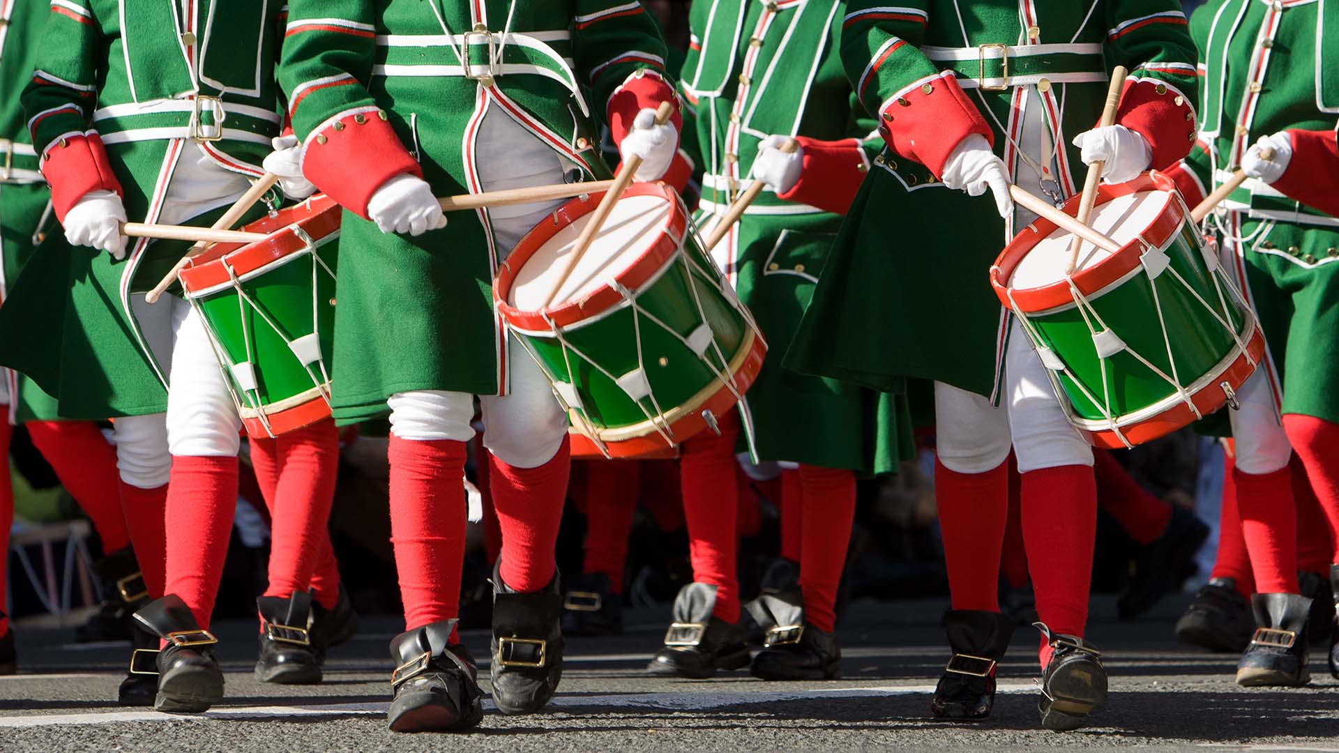 drummers dressed in green, white, and red parade in San Sebastian, Spain for the Tamborrada Festival
