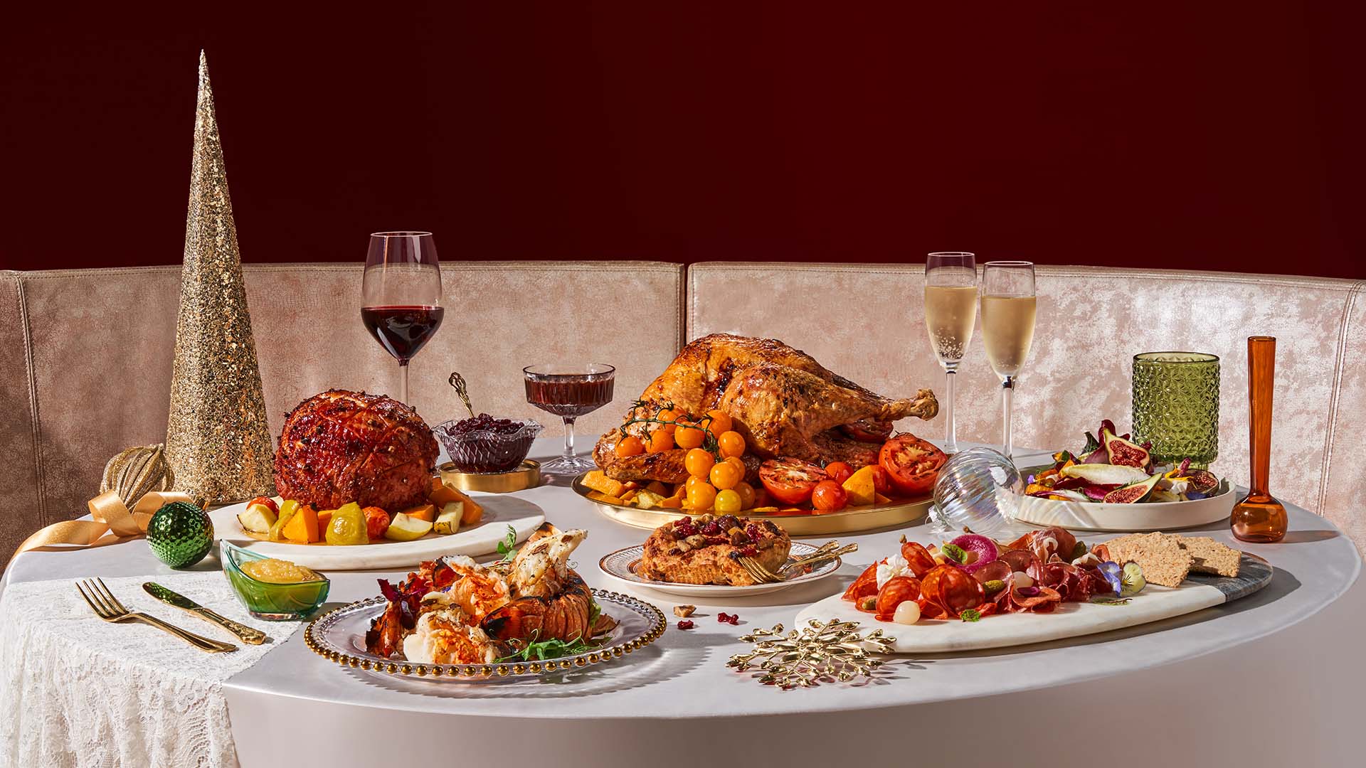 a holiday feast, glasses of wine and decor arranged on a table with a tablecloth