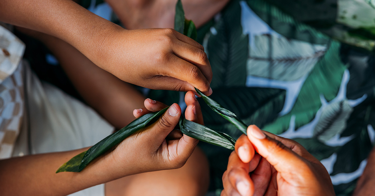 Close-up of hands making leis