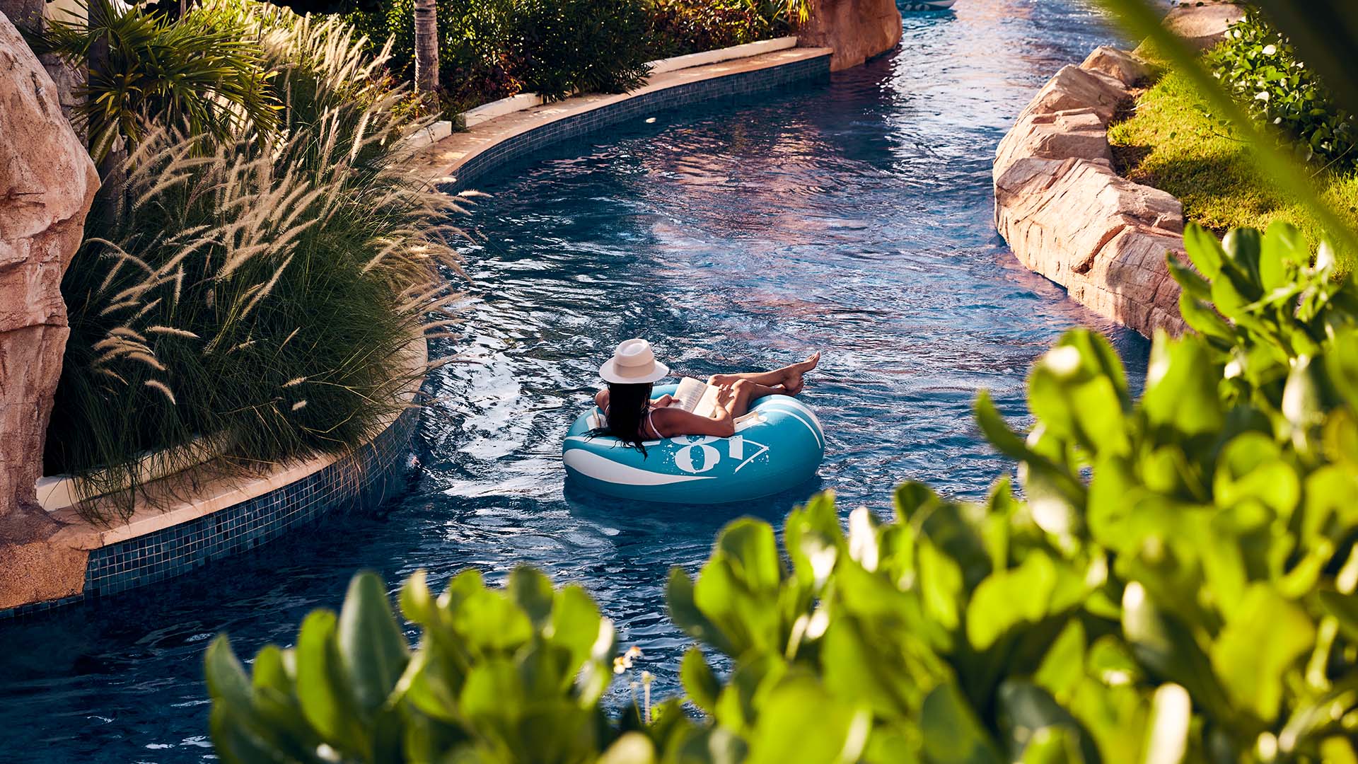 Woman reading a book and floating in a pool tube at a Marriott Bonvoy hotel