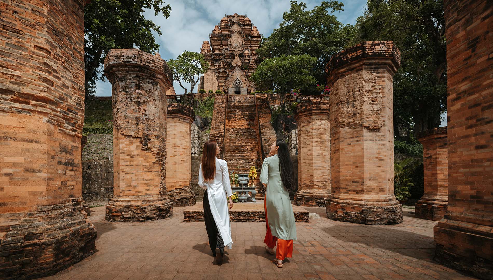Two people walking among the Po Nagar Cham Towers in Nha Trang, Vietnam
