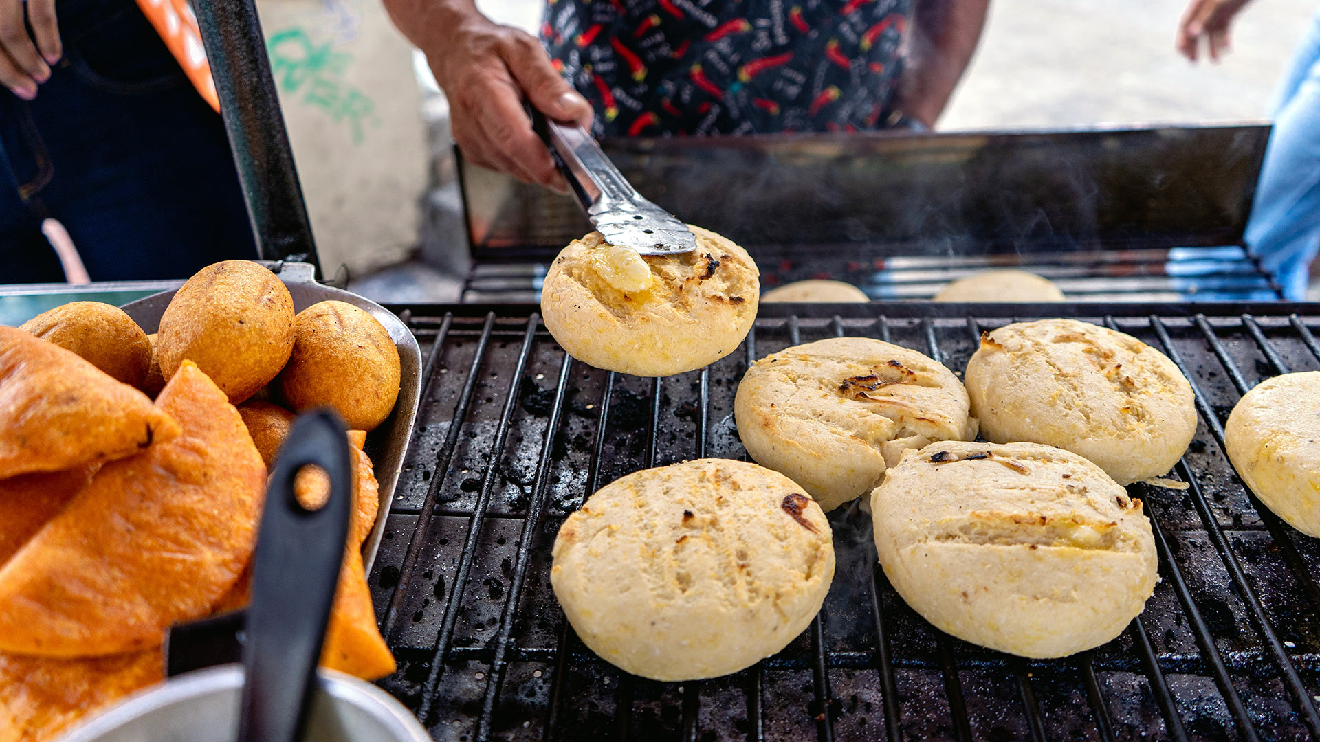 A man grills arepas in Bogota, Colombia