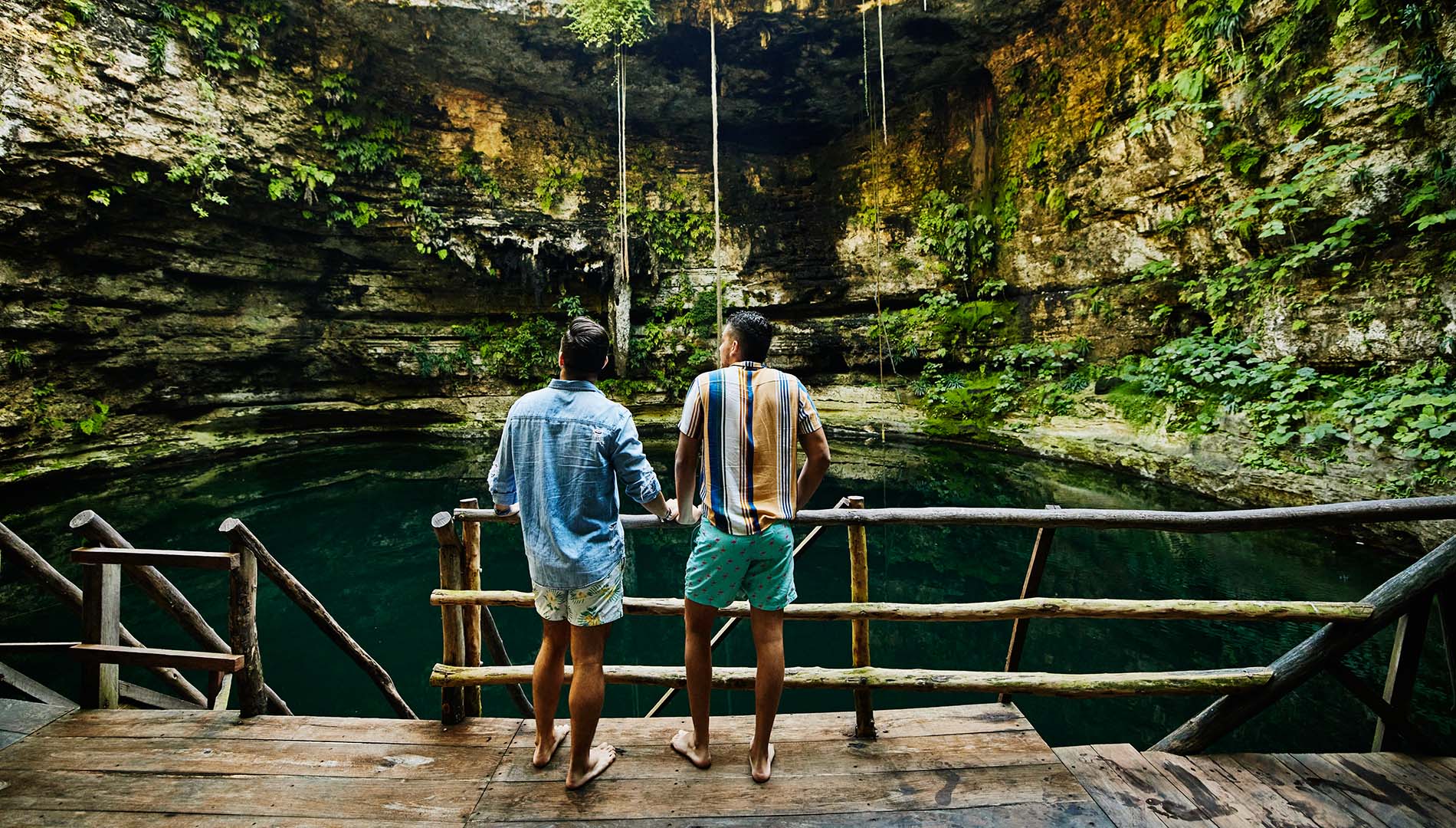 Two men look down at a cenote in Mexico