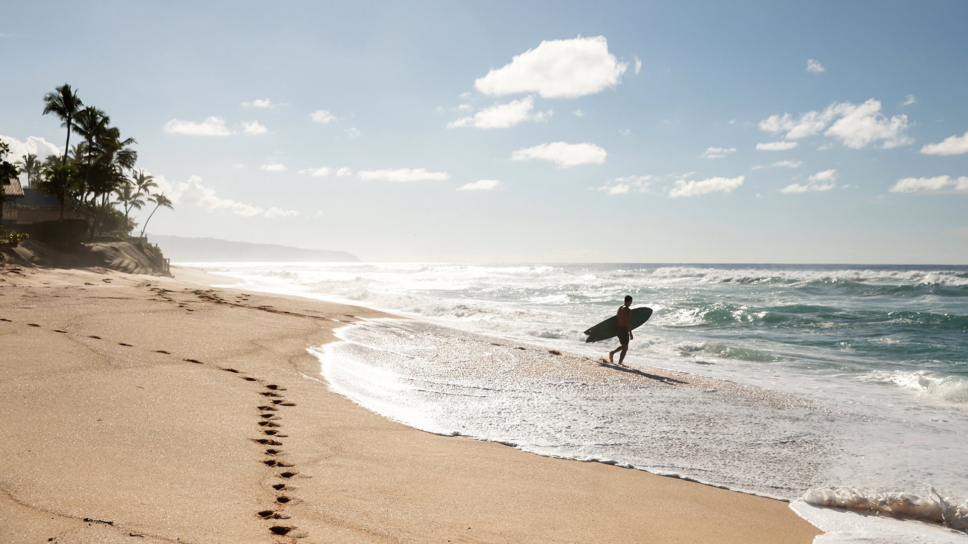 Surfer running on a beach in Oahu, Hawaii