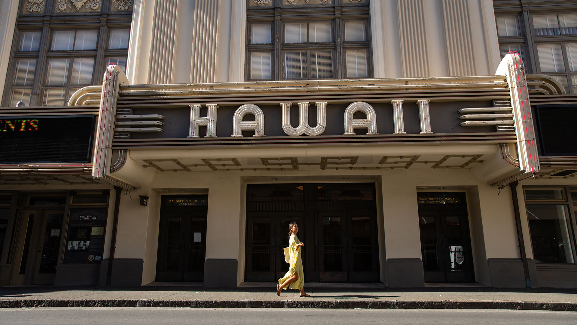 Woman walking down a street in Honolulu's Chinatown neighborhood