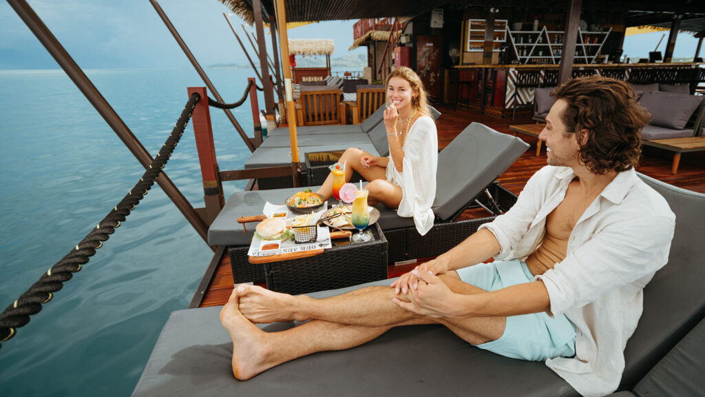couple eating on a floating restaurant in fiji.