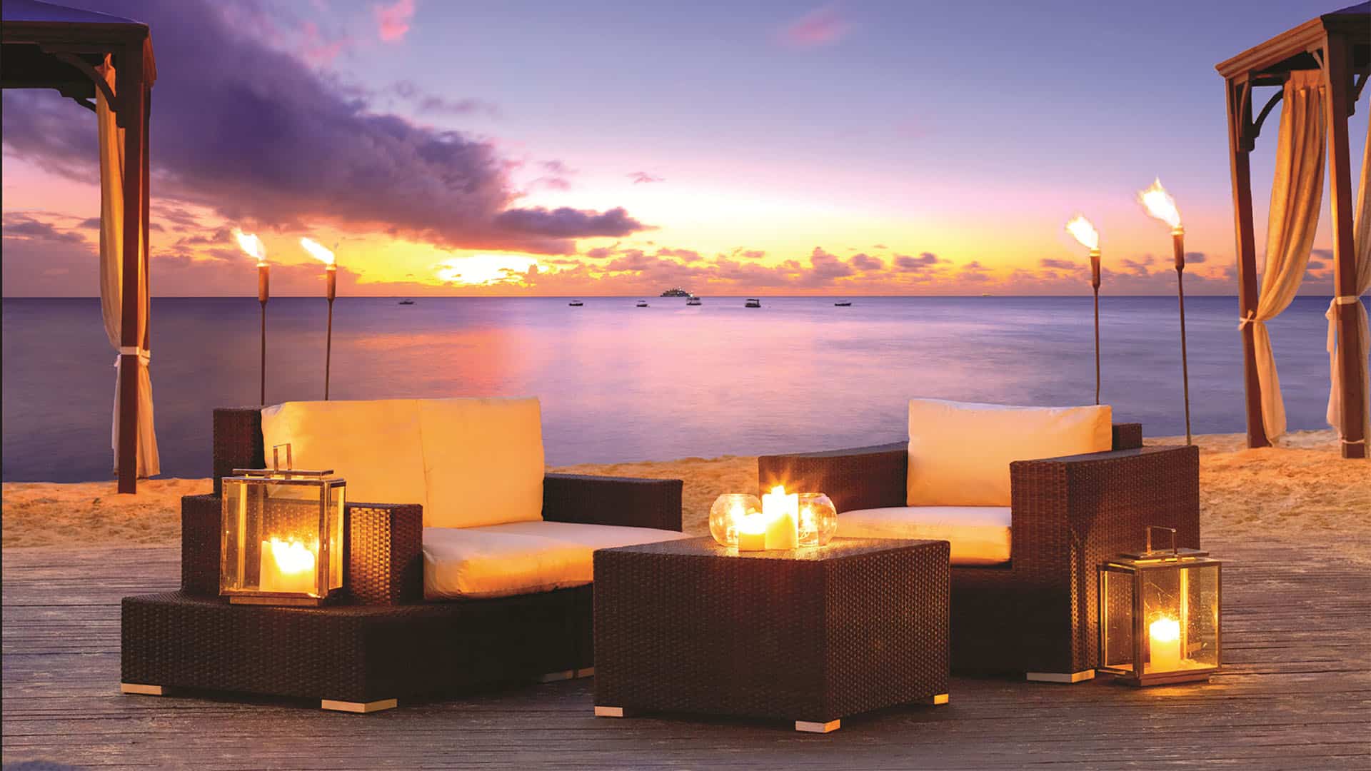 house elegant hotels beach deck with lounge chairs and candles.