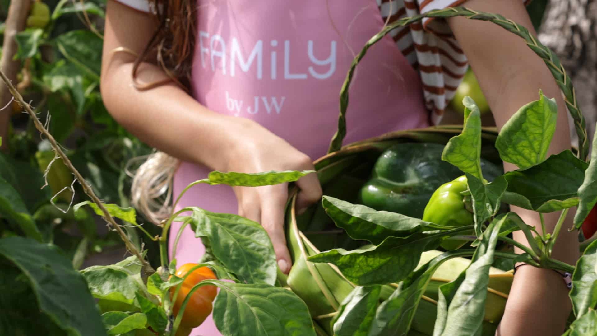A close-up of a child picking vegetables as part of the Chefs in the Making program at JW Marriott Maldives Resort & Spa