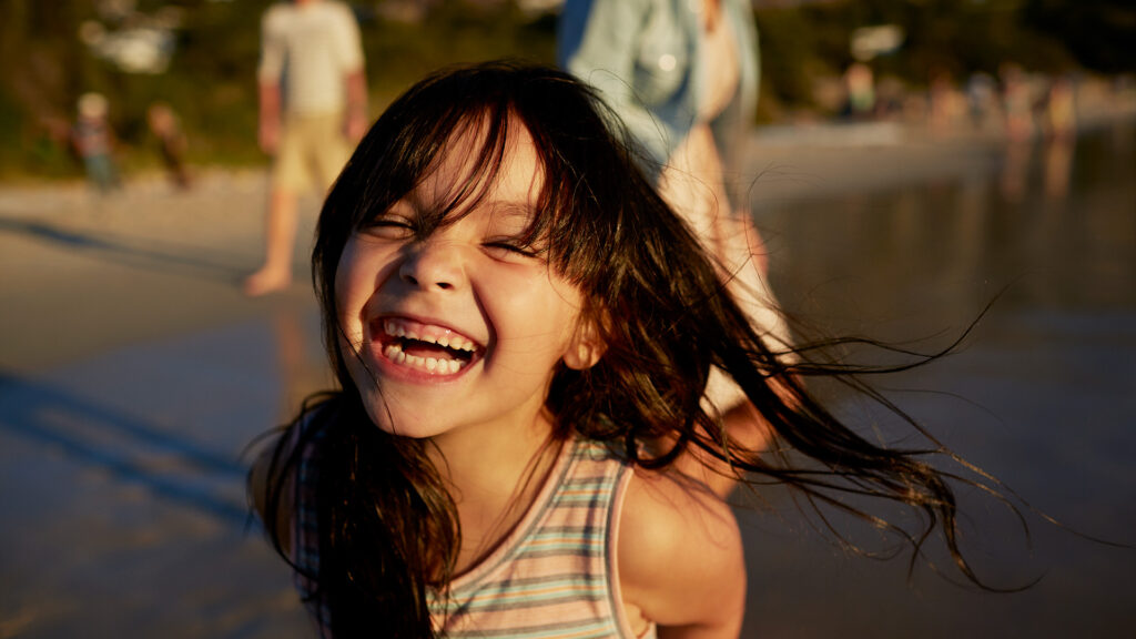 A child smiling on the beach